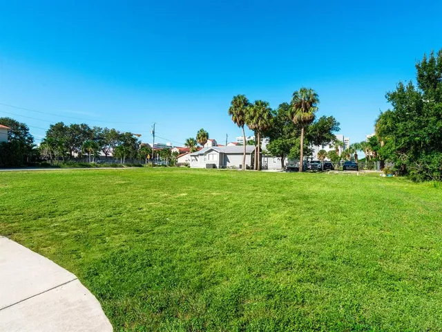 a view of a grassy field with trees in the background