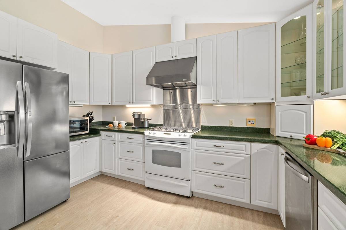 6427 Puupilo Road Kapaa, HI 96746 - Photo 5 of 27 a kitchen with granite countertop white cabinets and stainless steel appliances