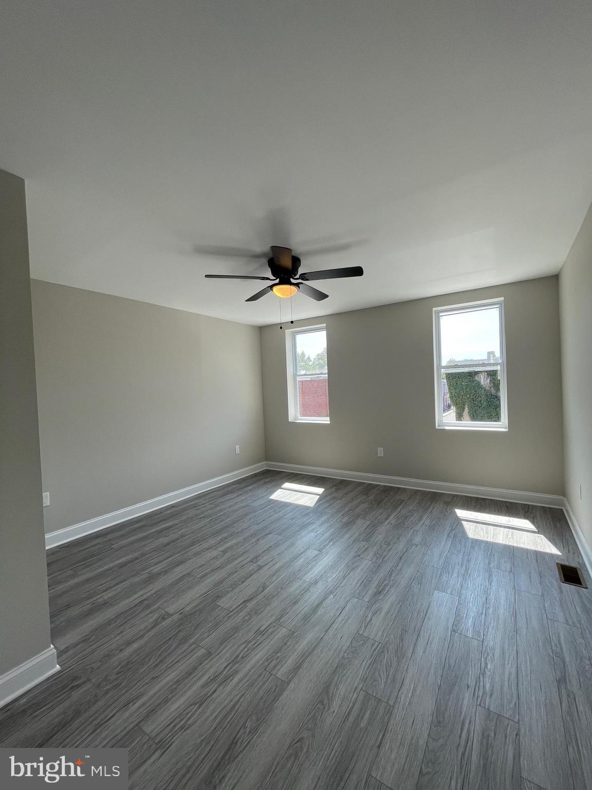 1806 East Lanvale Street Baltimore, MD 21213 - Photo 11 of 23 an empty room with wooden floor and windows