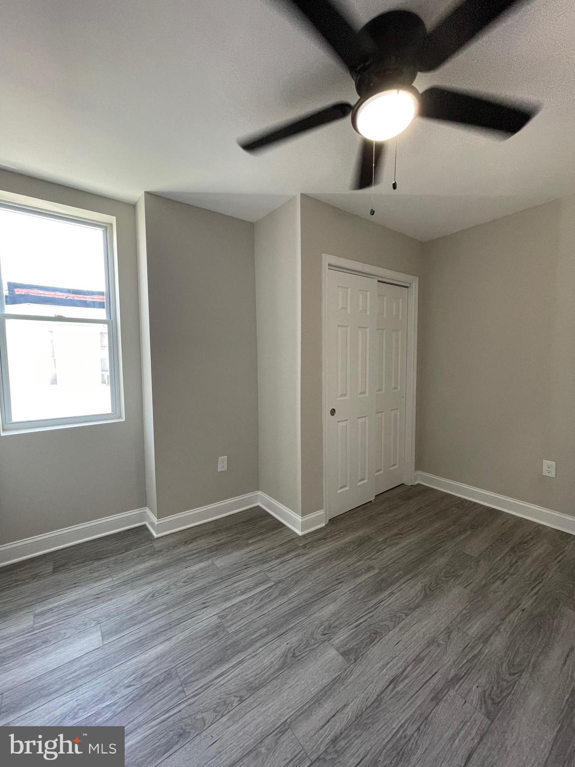 1806 East Lanvale Street Baltimore, MD 21213 - Photo 17 of 23 an empty room with wooden floor chandelier fan and windows
