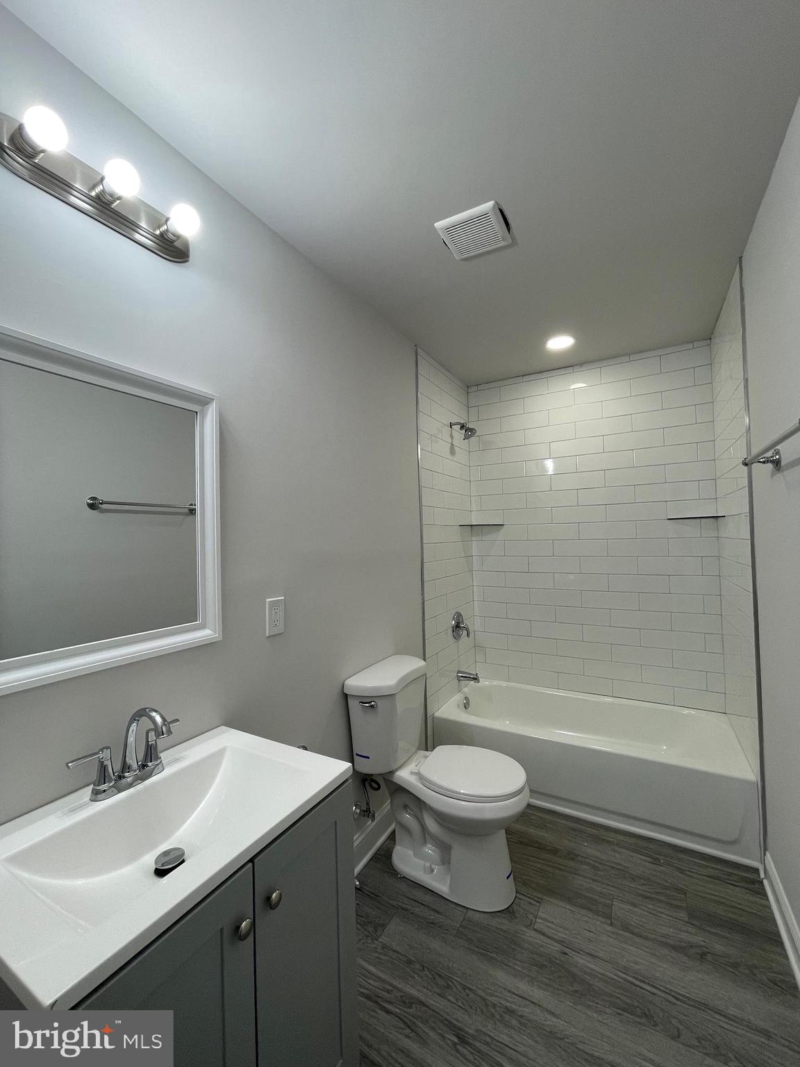 1806 East Lanvale Street Baltimore, MD 21213 - Photo 19 of 23 a bathroom with a bathtub shower sink mirror vanity and toilet