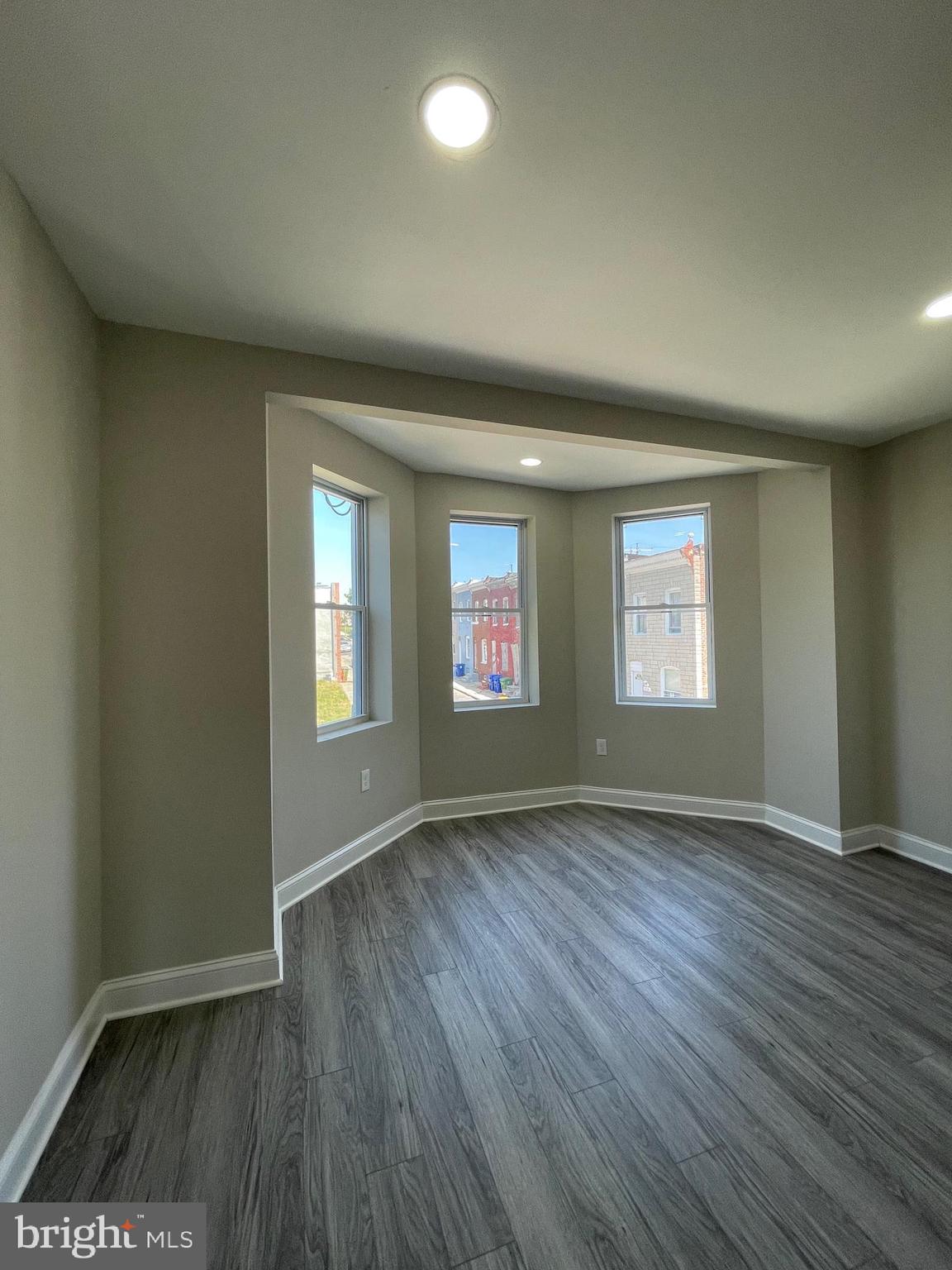 1806 East Lanvale Street Baltimore, MD 21213 - Photo 21 of 23 an empty room with wooden floor and windows