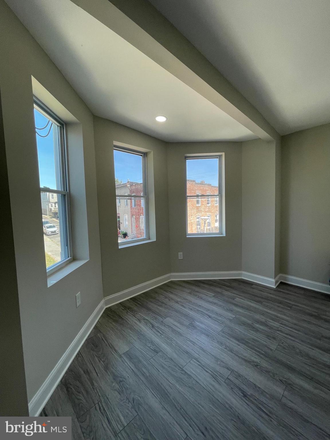1806 East Lanvale Street Baltimore, MD 21213 - Photo 23 of 23 a view of an empty room with wooden floor and a window
