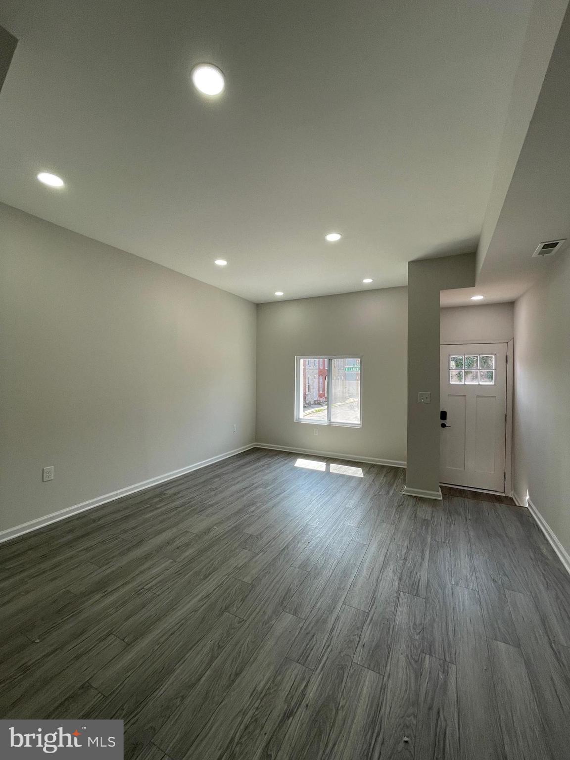 1806 East Lanvale Street Baltimore, MD 21213 - Photo 3 of 23 an empty room with wooden floor and windows