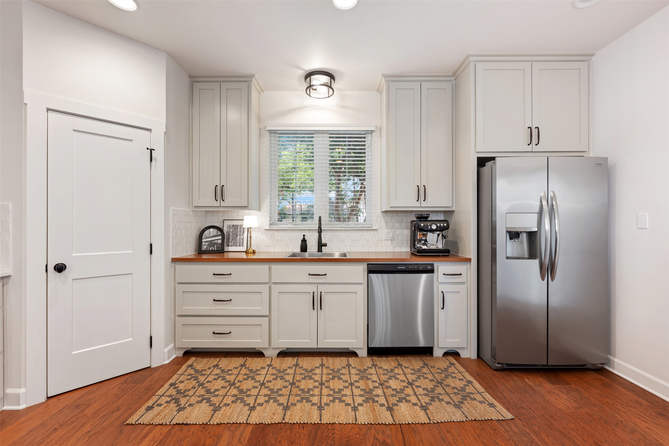 1301 West Street Georgetown, TX 78626 - Photo 14 of 40 Hardwood floors and sleek cabinetry frame a functional kitchen with modern amenities.