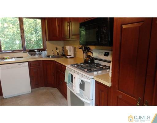 740 Old Raritan Road Edison, NJ 08820 - Photo 3 of 24 a kitchen with a sink cabinets stainless steel appliances and a window
