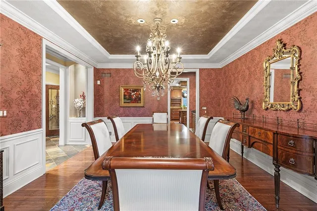 a view of a dining room with furniture a chandelier and wooden floor