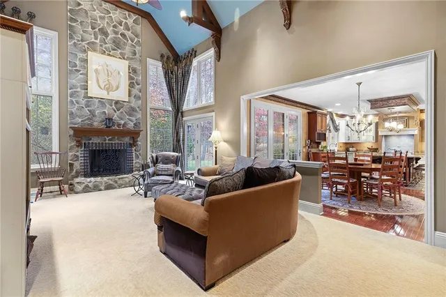 a living room with furniture a fireplace and a large window