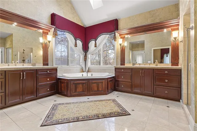 a spacious bathroom with a tub sink and mirror