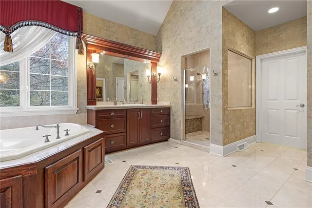 a spacious bathroom with a tub sink and mirror