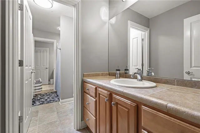 a bathroom with a granite countertop sink and a mirror