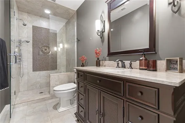 a bathroom with a double vanity sink toilet and shower