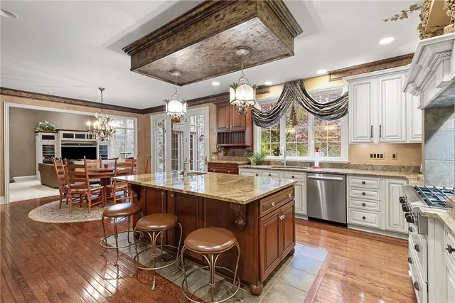 a kitchen with stainless steel appliances granite countertop a stove a sink and a refrigerator