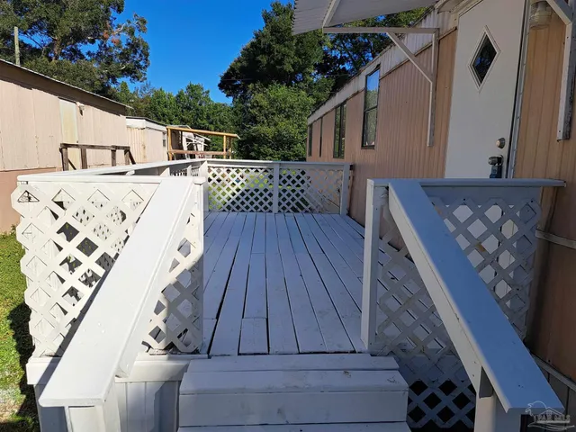a view of balcony with wooden floor and potted plants