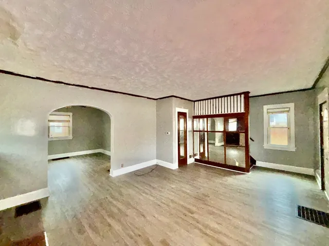 a view of a livingroom with wooden floor and staircase
