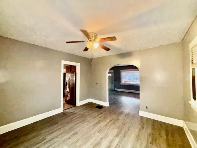 a view of a livingroom with wooden floor and a ceiling fan
