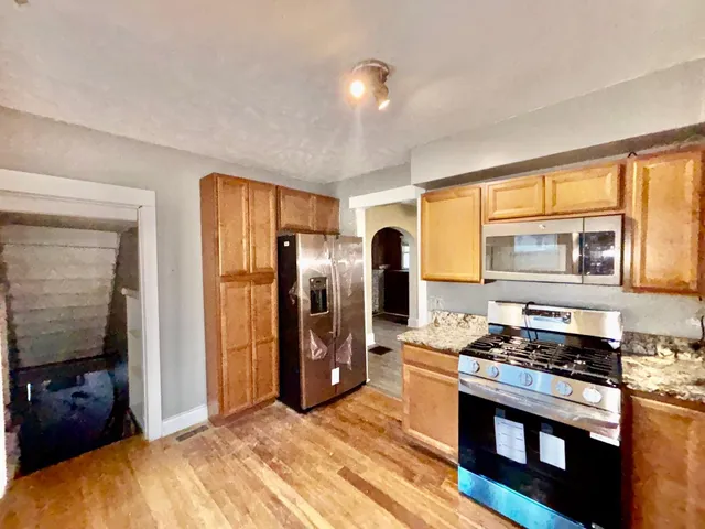 a kitchen with stainless steel appliances granite countertop a refrigerator stove and sink