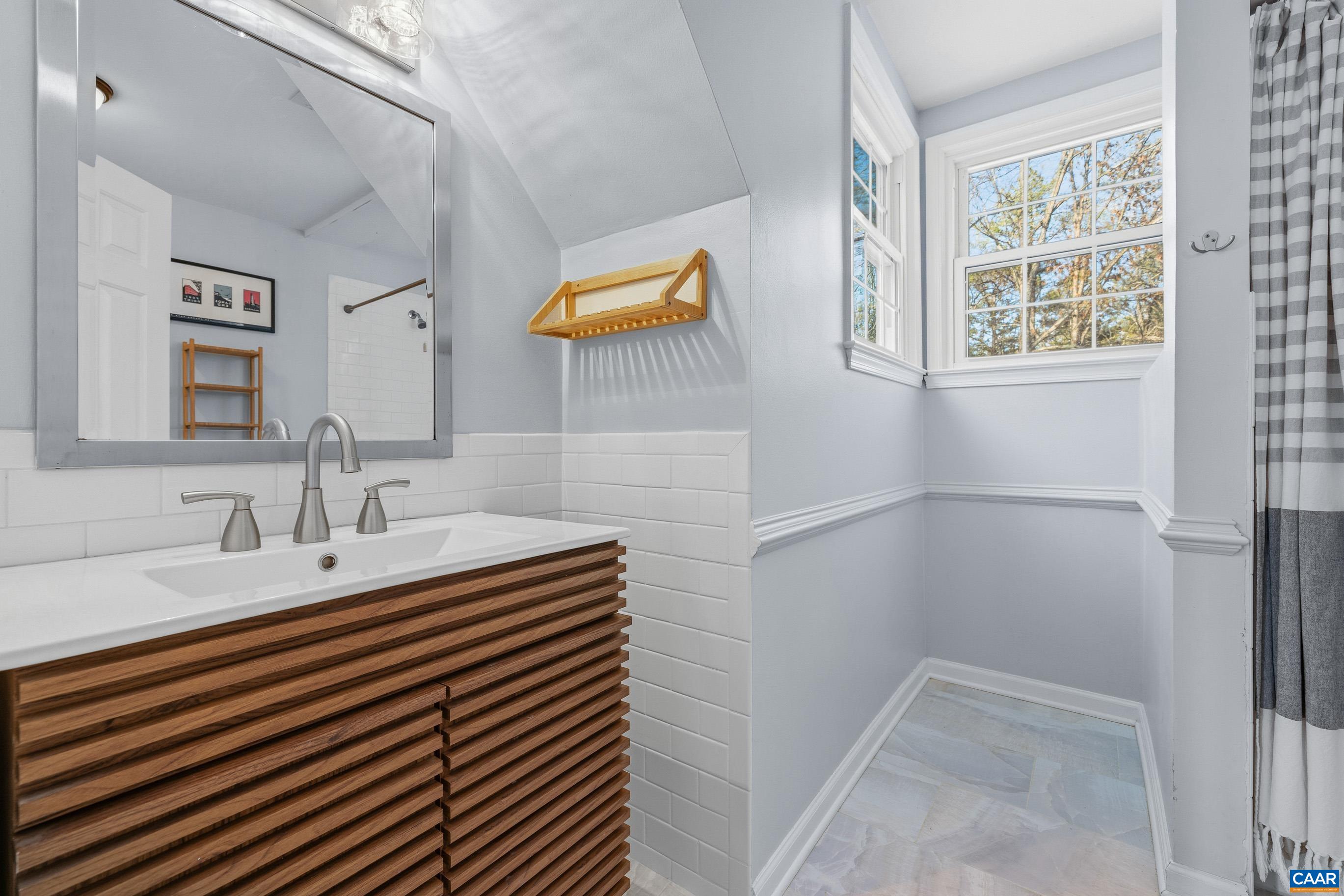 1284 Tilman Road Charlottesville, VA 22901 - Photo 28 of 36 a bathroom with a sink a mirror and a shower
