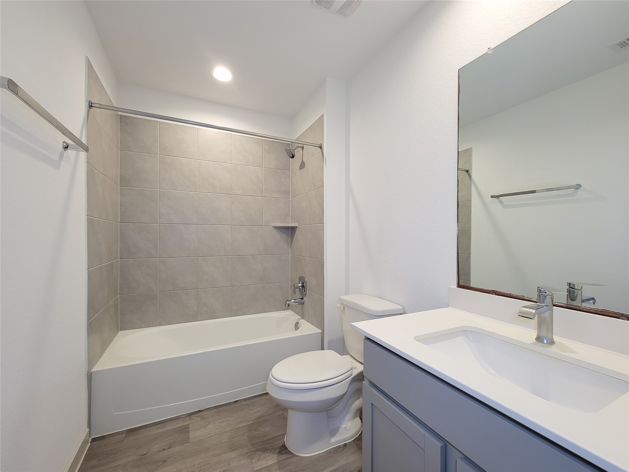 7722 Caldwell Crk Way Rosharon, TX 77583 - Photo 24 of 40 This modern bathroom features a sleek vanity with a large mirror, a bathtub with a tiled shower area, and a minimalist design with neutral tones.