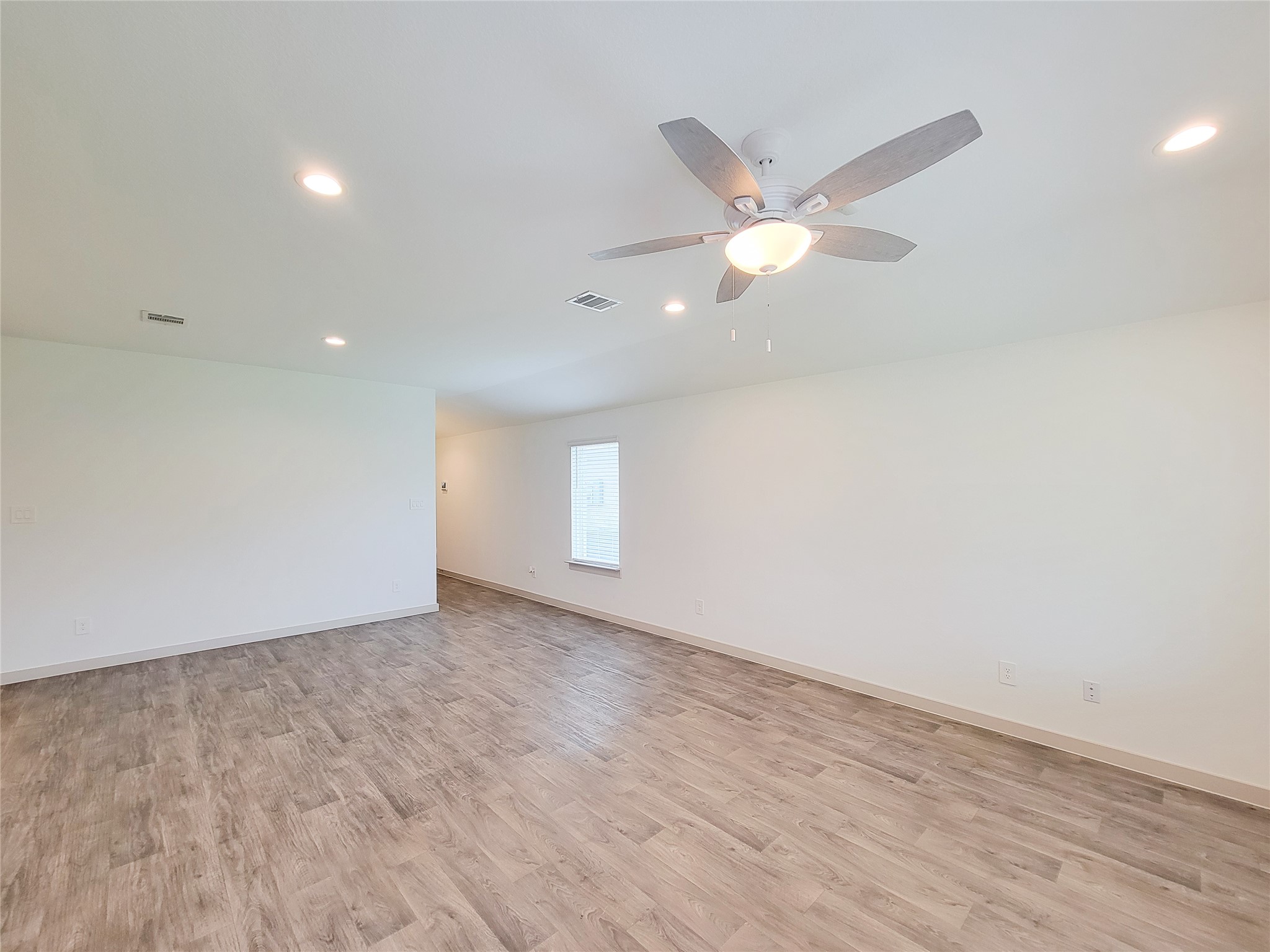7722 Caldwell Crk Way Rosharon, TX 77583 - Photo 32 of 40 This spacious room features wood-look flooring, recessed lighting, and a ceiling fan, creating a bright and airy atmosphere.