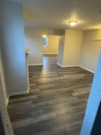 a view of empty room with wooden floor