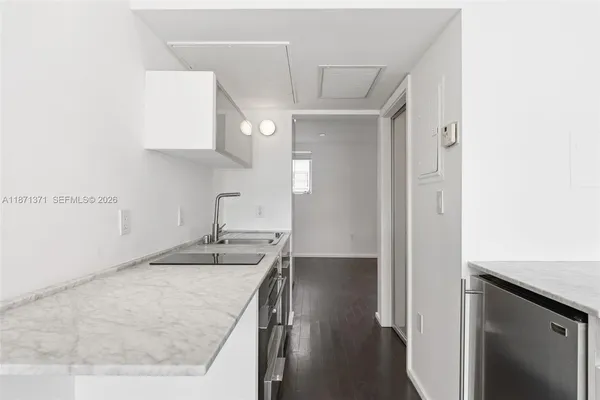 a kitchen with a sink cabinets and wooden floor
