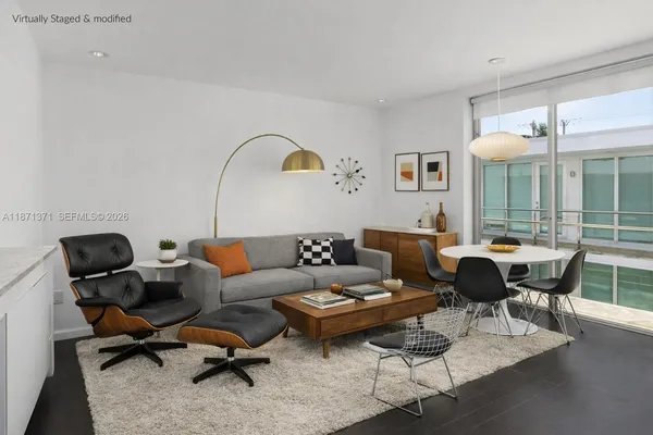 a living room with furniture a table and large windows