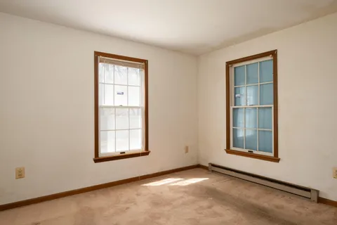 an empty room with windows and closet