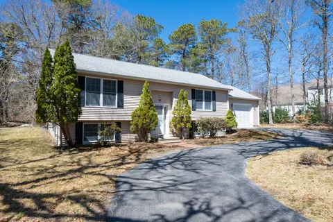 a view of a house with a yard and tree s