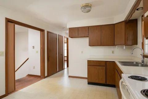 a kitchen with a refrigerator sink and cabinets