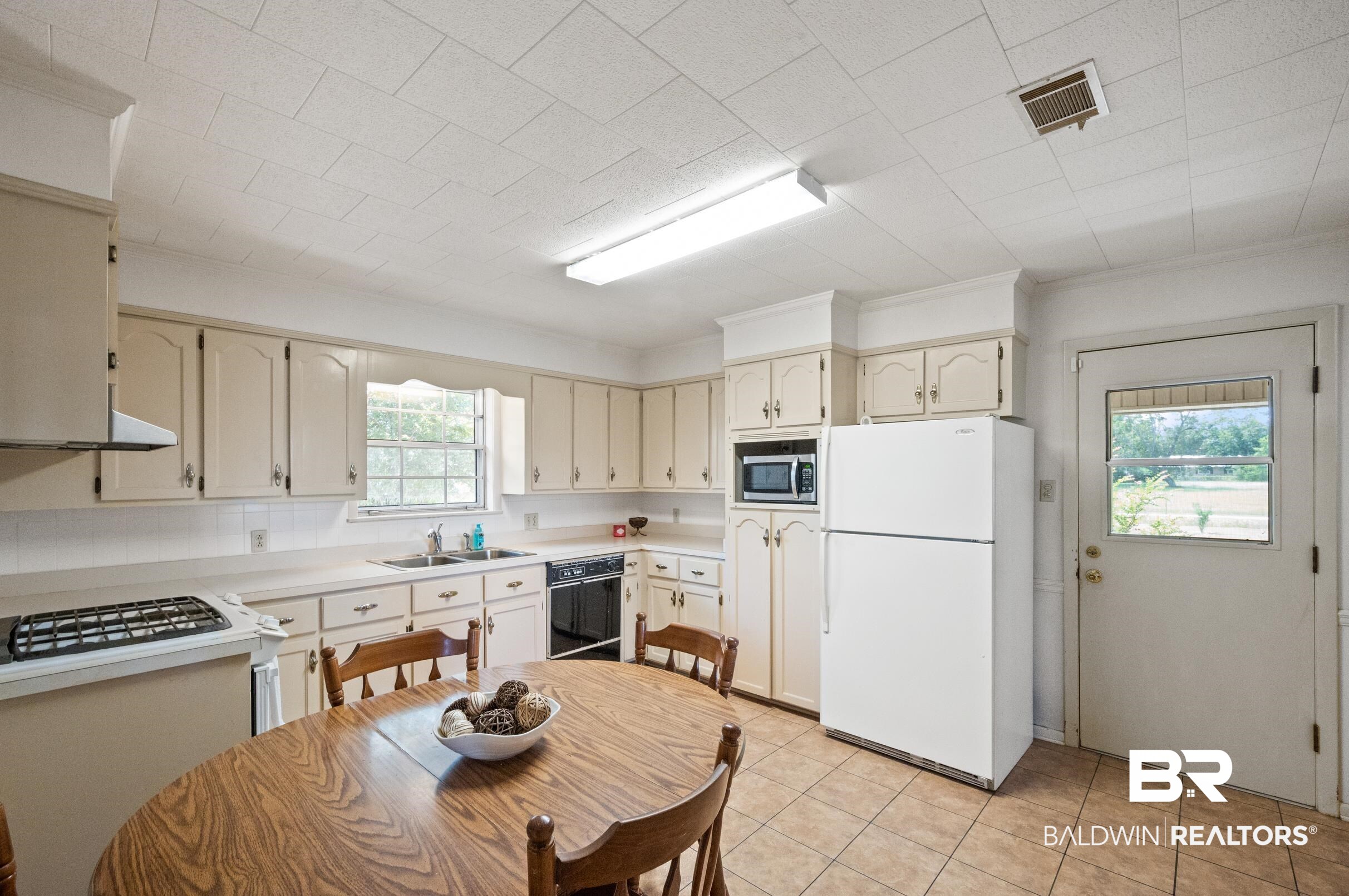 15600 Fackler Road Loxley, AL 36551 - Photo 9 of 51 Kitchen with sink, light tile patterned floors, a healthy amount of sunlight, and white fridge