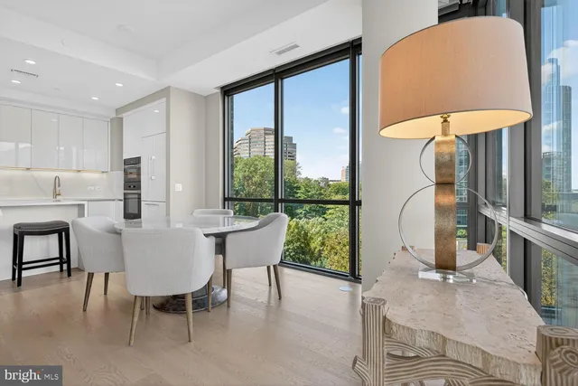 a dining room with furniture large windows and a rug