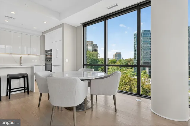 a dining room with furniture and a floor to ceiling window
