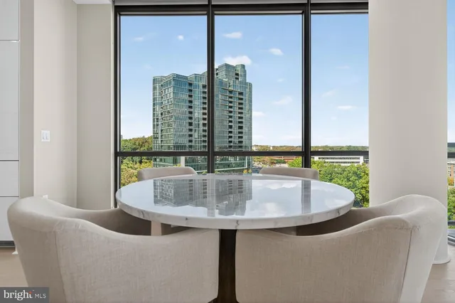a kitchen with stainless steel appliances a table chairs in it and wooden floors