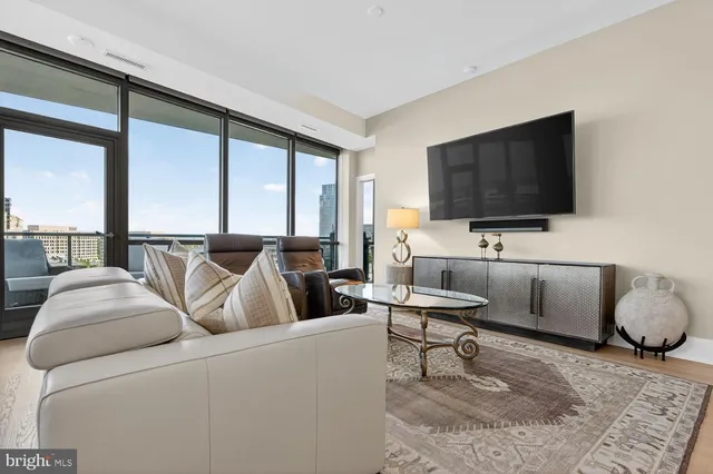 a living room with furniture and a floor to ceiling window