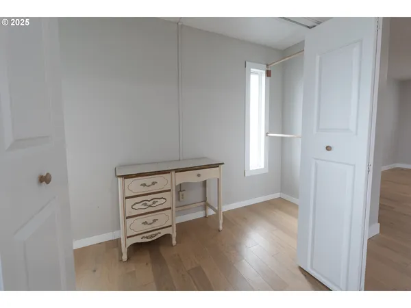 a view of a bedroom with wooden floor