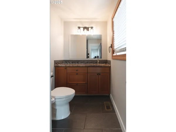 a bathroom with a toilet a sink and mirror