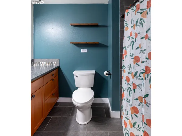 a bathroom with a toilet and a shower curtain