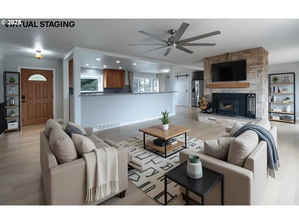 a living room with furniture a flat screen tv and kitchen view