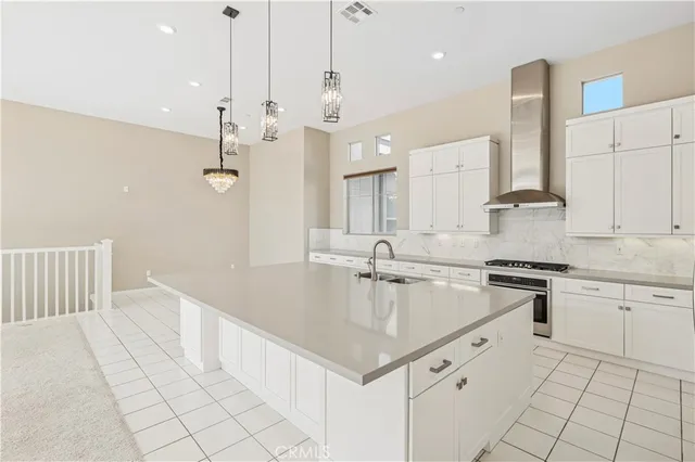 a large white kitchen with a large window cabinets and stainless steel appliances