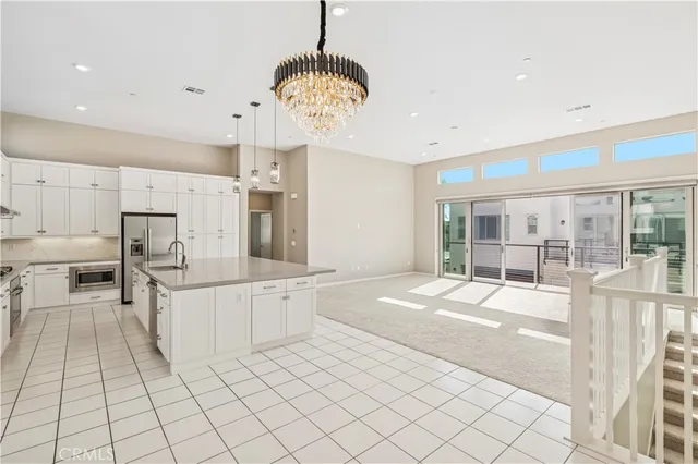 a large kitchen with kitchen island a stove a sink a center island and windows