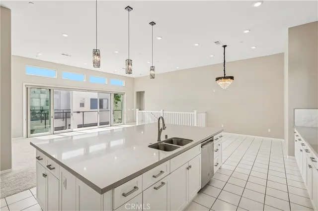 a large white kitchen with stainless steel appliances kitchen island granite countertop a stove a sink a refrigerator and a window