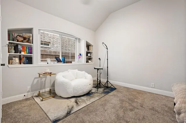 a living room with furniture and a book shelf