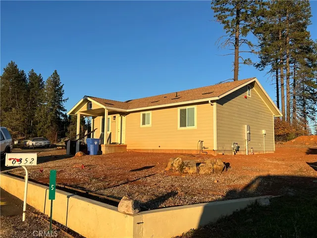 a view of a house with backyard and trees