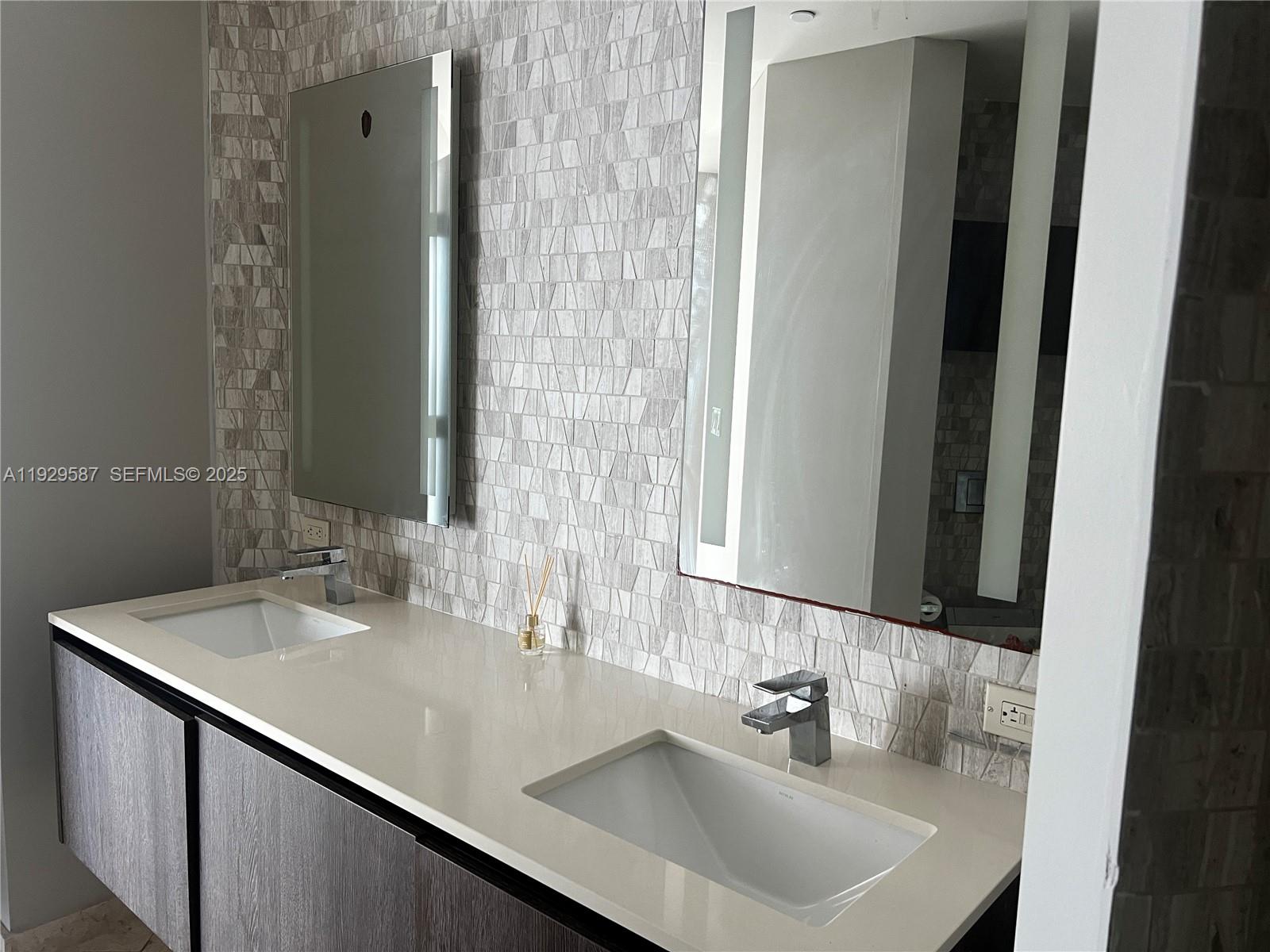 68 Southeast 6th Street, Unit 3401 Miami, FL 33131 - Photo 12 of 23 a bathroom with a sink and a mirror