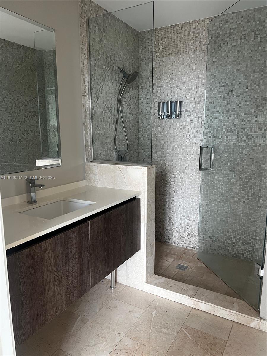 68 Southeast 6th Street, Unit 3401 Miami, FL 33131 - Photo 13 of 23 a bathroom with a sink and a mirror