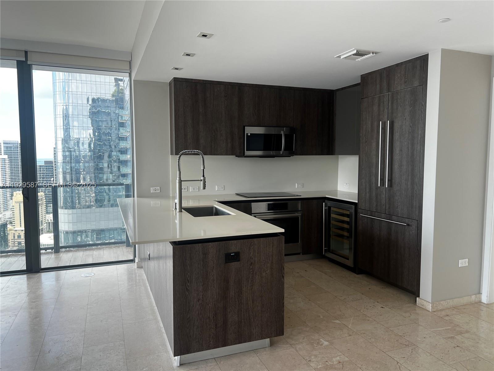 68 Southeast 6th Street, Unit 3401 Miami, FL 33131 - Photo 6 of 23 a kitchen with stainless steel appliances a stove a refrigerator and a sink