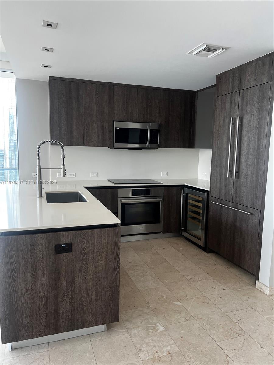 68 Southeast 6th Street, Unit 3401 Miami, FL 33131 - Photo 7 of 23 a kitchen with stainless steel appliances a sink and a refrigerator