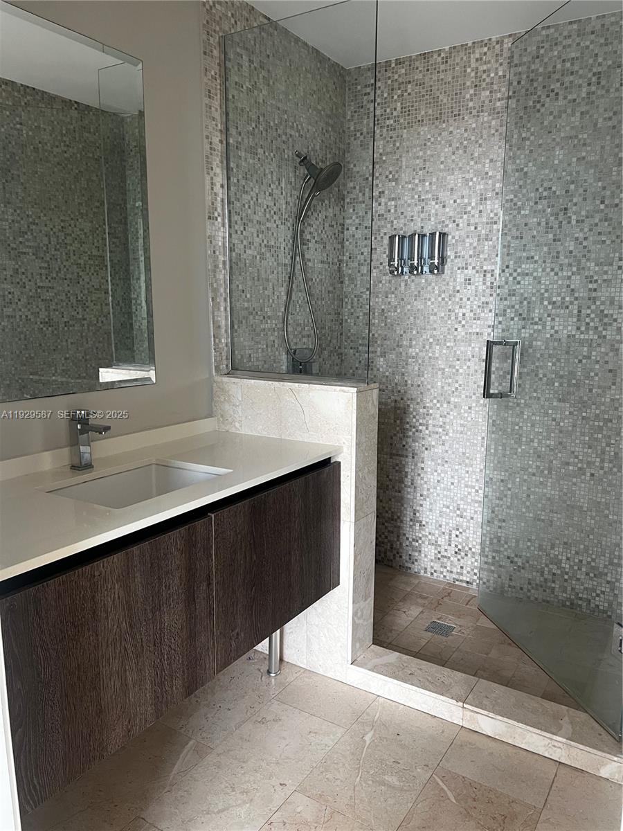 68 Southeast 6th Street, Unit 3401 Miami, FL 33131 - Photo 9 of 23 a bathroom with a sink and a mirror