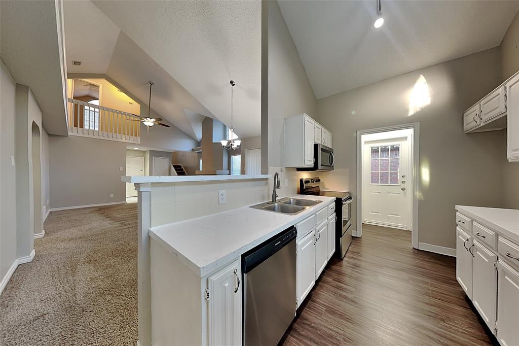 1213 Broken Arrow Trail Carrollton, TX 75007 - Photo 17 of 19 a open kitchen with a sink and wooden floor